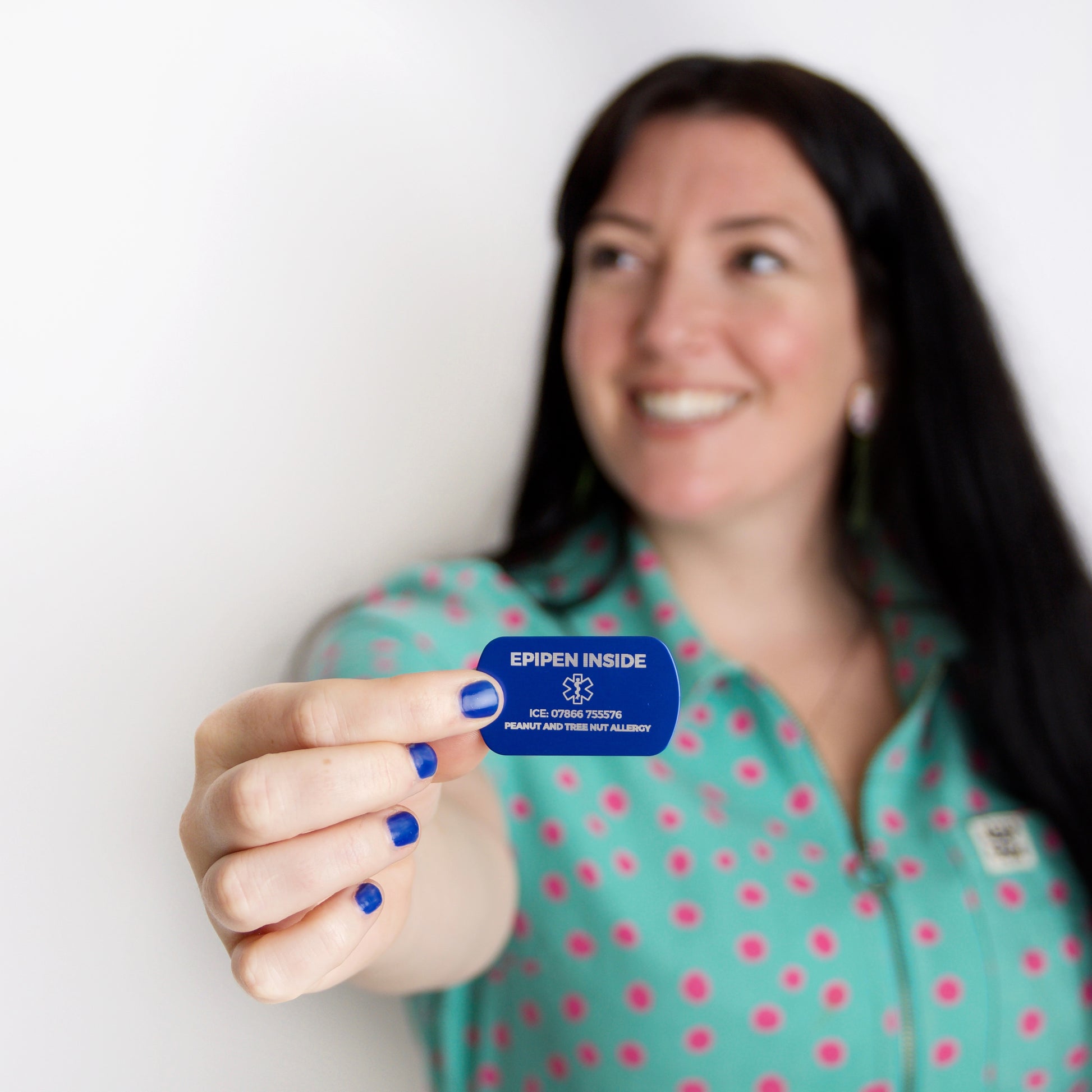 Woman holding a blue card with 'EPIPEN INSIDE' text against a white background