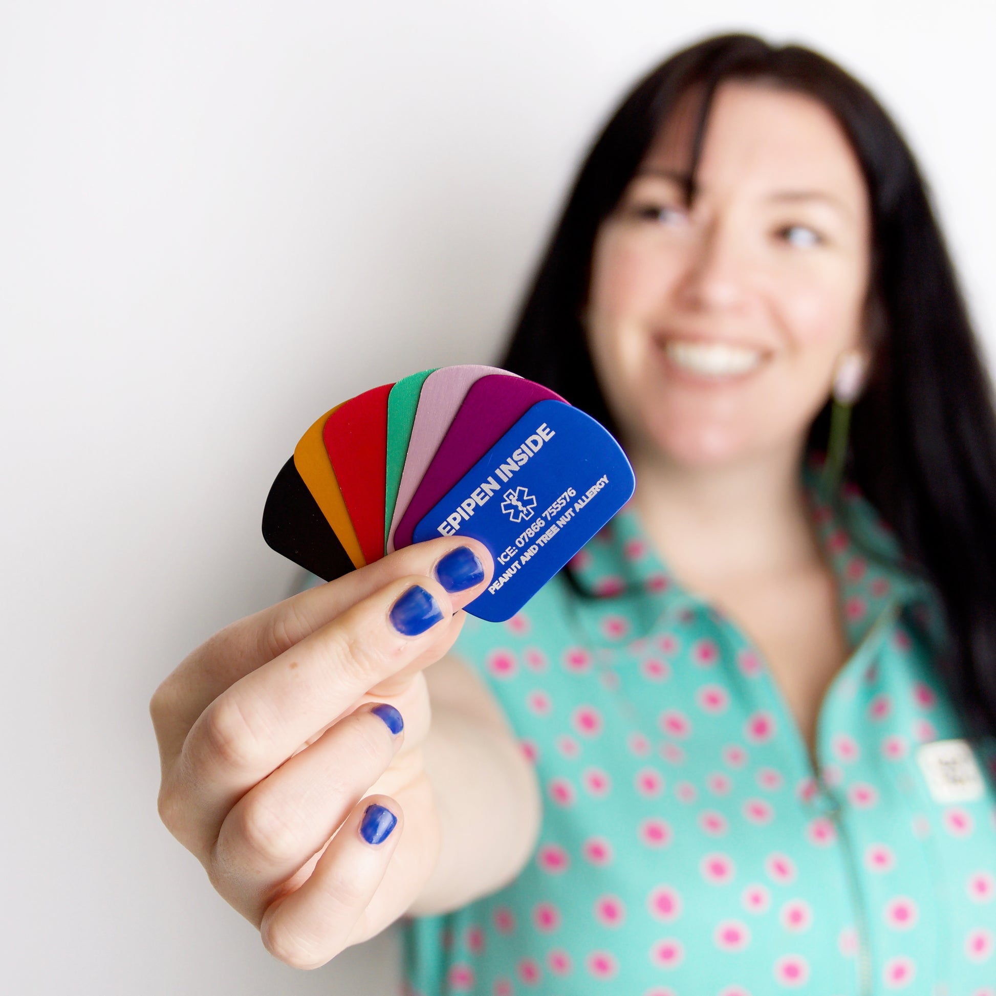 Woman holding a colorful card with text, smiling against a white background