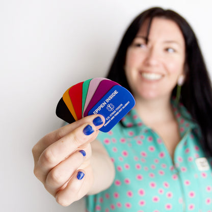Woman holding a colorful card with text, smiling against a white background